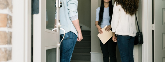 people standing in doorway of home