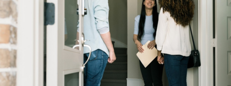 people standing in doorway of home