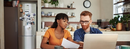woman and man discussing finances at kitchen table